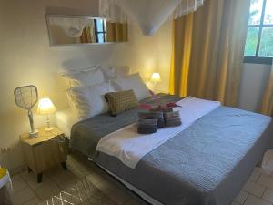 a bedroom with a bed with two pillows on it at Perle de l'océan in Les Anses-dʼArlets