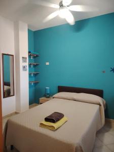 a bedroom with a bed with a blue wall at Bed & Breakfast Gli Alisei in Siniscola