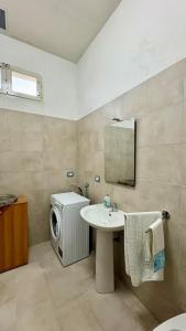 a bathroom with a sink and a washing machine at B&B Martina in Martignano +11 photos