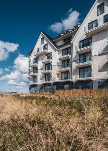 budynek mieszkalny na plaży z wysoką trawą w obiekcie Hotel de Schelde w mieście Cadzand-Bad