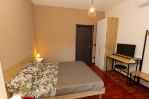 a bedroom with a bed and a desk and a television at Dimora Nicotera in Lamezia Terme