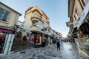 a woman walking down a cobblestone street with buildings at Villa Sveti Gorgi in Ohrid
