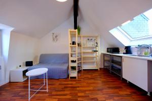 a bedroom with a bed and a desk and a window at Le toit des Carmes in Rouen