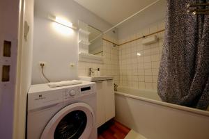 a white washing machine in a bathroom with a shower at Le toit des Carmes in Rouen