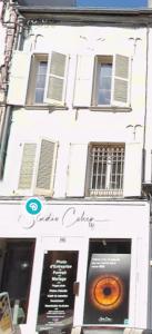 a white building with a donut shop on a street at T2 Hyper centre Senlis in Senlis