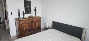 a bedroom with a bed and some statues on a dresser at Marseille Estaque in Marseille