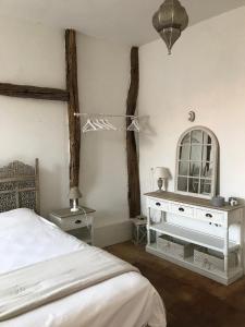 a bedroom with a bed and a mirror on the wall at Gîte de l'oiseau bleu in Lautrec