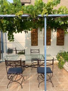 a glass table and two chairs under an umbrella at Gîte de l'oiseau bleu in Lautrec