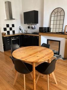 a wooden table in a kitchen with a table and chairs at Gîte de l'oiseau bleu in Lautrec +10 photos