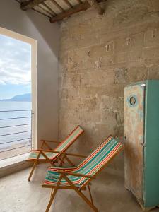 two chairs and a refrigerator in a room with a window at Cielomare Residence Diffuso in Trapani