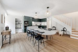 a dining room with a white table and chairs at Belle maison 8 personnes à 600m de la plage avec parking privé in Dinard