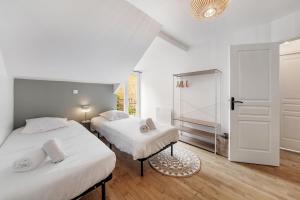two beds in a room with a door and a mirror at Belle maison 8 personnes à 600m de la plage avec parking privé in Dinard