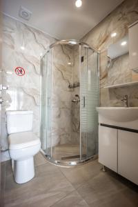 a bathroom with a shower and a toilet and a sink at Dimitra Beach Apartments 2 in Nea Karvali +78 photos
