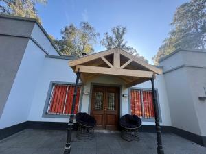 a house with a wooden door and two baskets at Viento Potro Casa Quinta de Campo in San Miguel del Monte