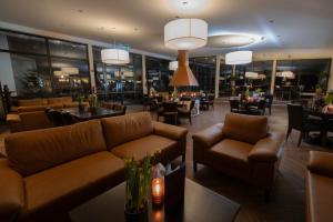 a restaurant with leather couches and tables and chairs at Hotel Winterberg Resort in Winterberg