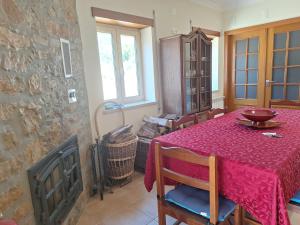 a dining room with a table with a red table cloth at Casa do Pastana in Ancião