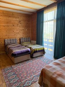 two beds sitting in a room with a window at Panorama Gomarduli in Shuakhevi