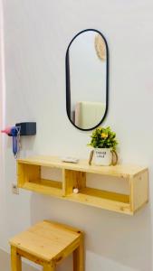 a mirror on a wall next to a wooden shelf at The Heaven Luxe Pangandaran in Pangandaran +6 photos