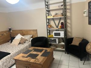 a bedroom with a bed and a table and chairs at Pause à Beaucaire avec garage à vélo ou moto in Beaucaire