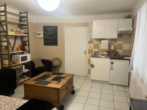 a small kitchen with a table and a refrigerator at Pause à Beaucaire avec garage à vélo ou moto in Beaucaire