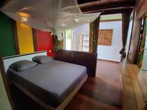 a bedroom with a bed with a canopy at Lodge Kunawalu in Roura