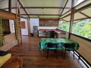 a kitchen with a table and chairs in a room at Lodge Kunawalu in Roura