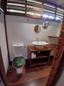 a bathroom with a sink and a toilet and a mirror at Lodge Kunawalu in Roura