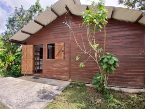 a small house with a wooden exterior at Lodge Kunawalu in Roura +7 photos