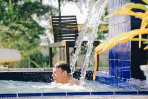 a man in a swimming pool under a fountain at Dinuda Lagoon Hotel in Kalpitiya