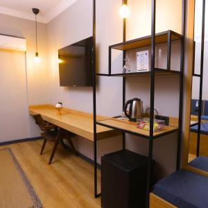 a room with a table and a desk with a television at Esin Hotel in Denizli