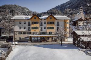a large yellow and white building in the snow at Ferienhaus/Chalet Schneiderhäusl in Flachau +6 photos