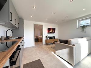 a kitchen and living room with a couch and a table at An der Grüh in Großsolt