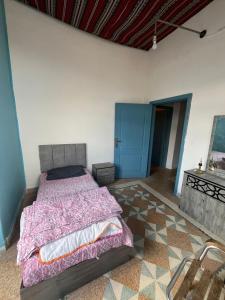 a bedroom with a bed and a blue door at The Blue House in Amman
