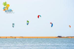 a group of people flying kites over the water at Dinuda Lagoon Hotel in Kalpitiya