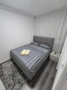 a bedroom with a bed with two towels on it at Apartman Central Lux in Banja Luka