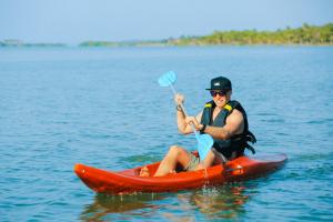 a man sitting on a kayak in the water at Dinuda Lagoon Hotel in Kalpitiya