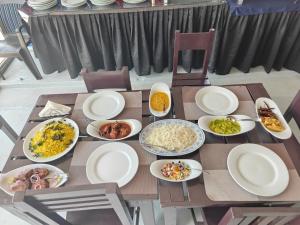a wooden table topped with plates and bowls of food at Dinuda Lagoon Hotel in Kalpitiya +157 photos