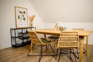 a dining room table with rattan chairs and a table at Fewo Wolke in Menslage