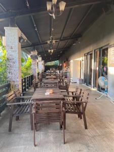 a row of wooden tables and chairs on a patio at Pet Truelove in Hengchun South Gate