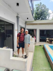 two men standing on the porch of a house at Pamarayeg Room in Bilar