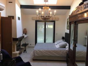 a bedroom with a bed and a chandelier at La Becada de las Landas in Seignosse