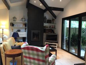 a living room with a couch and a tv at La Becada de las Landas in Seignosse