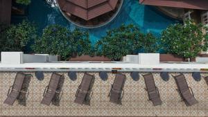 a row of tables with trees on a building at Quality Beach Resorts and Spa Patong in Patong Beach