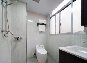a bathroom with a toilet and a sink and a window at Astria Moruo Retreat in Xinglong