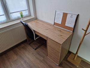 a wooden desk with a chair next to a window at Einzelzimmer in ruhiger Lage --- Check-In mit Schlüsselkasten in Meppen
