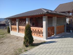 a house with a wooden fence and a porch at Pensiunea Ovidiu in Beclean
