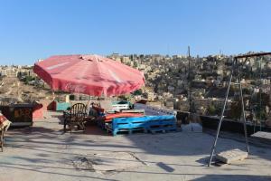 a red umbrella sitting on top of a building at The Blue House in Amman