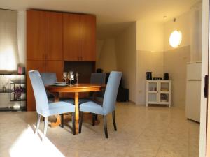 a dining room with a wooden table and blue chairs at Civico 55 in Casale Torre San Giovanni