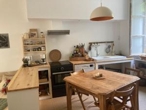 a kitchen with a wooden table and a wooden dining table at Studio à l'entrée de ma maison in Aubusson