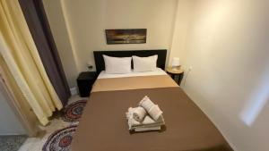 a bedroom with a bed with two pillows on it at Loutraki Suites in Loutraki